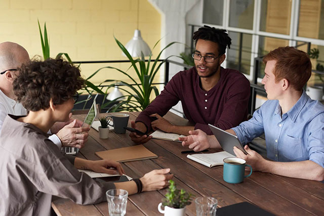 Réunion d’équipe illustrant les services d’orientation et de consolidation de LinkedU, avec partage d’idées et discussion collaborative