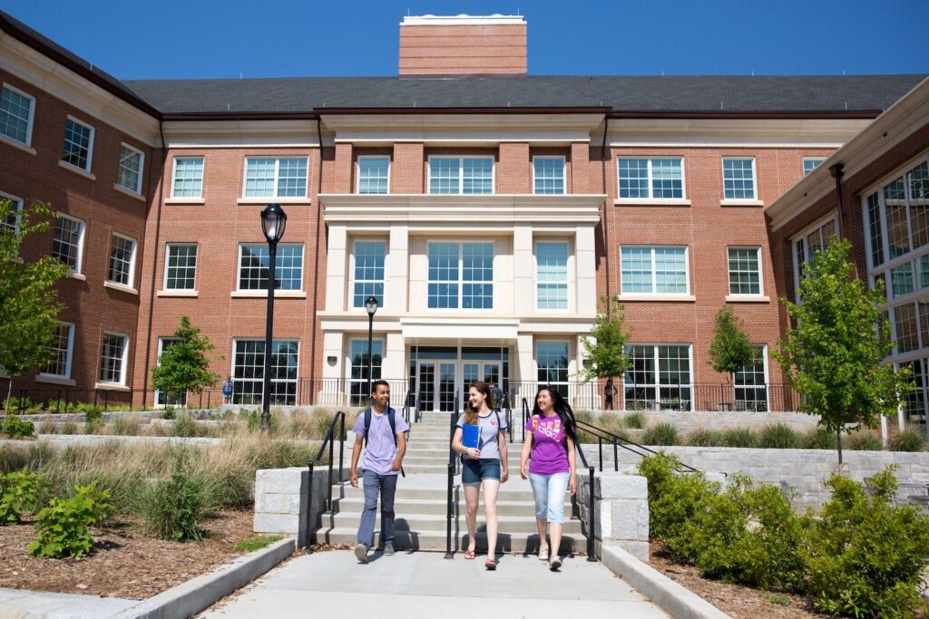 Étudiants internationaux sortant de l'Université de Harvard avec des diplômes, souriants